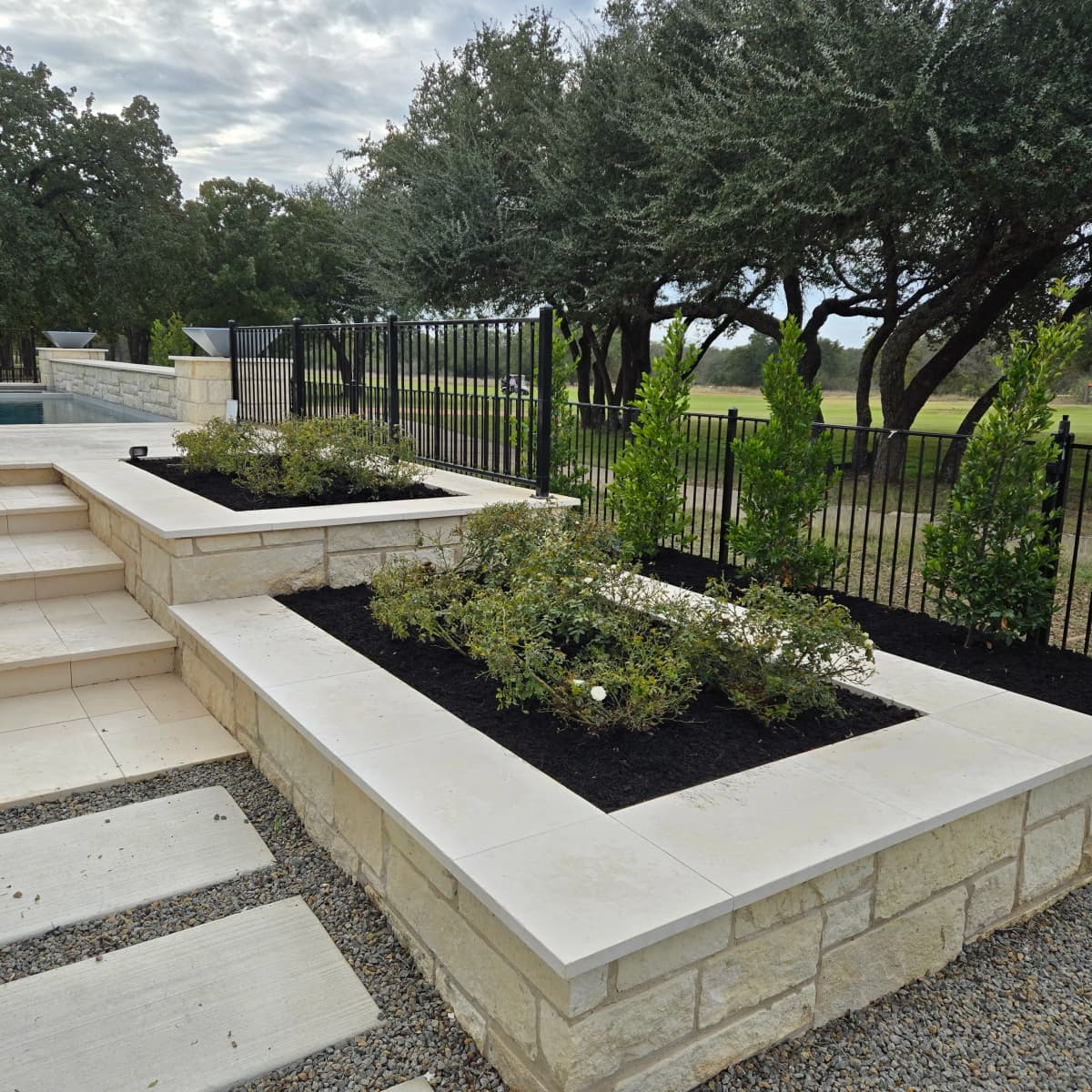 Raised limestone beds with fresh dark mulch and new planting